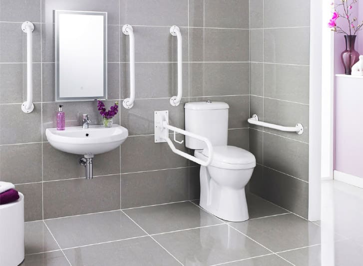 A bathroom with a toilet, sink and shower, featuring nylon grab bars for added safety and accessibility for the aged.