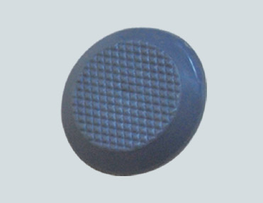 A blue button on a white background surrounded by stainless steel studs.