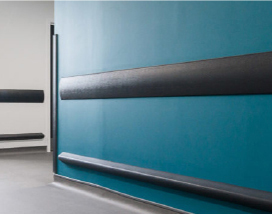 A blue wall with black stripes enhanced by PVC Corner & Wall Guard Protection Solutions from Warrior WPS.