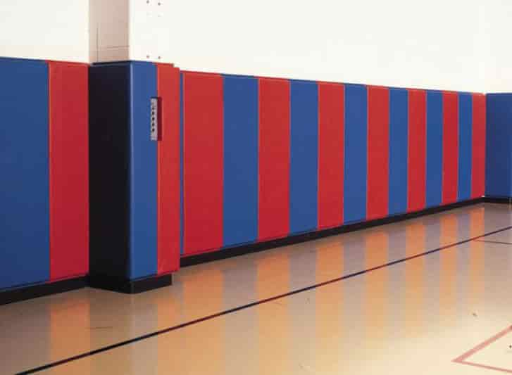 A red, blue, and white striped Foam Corner in a gym.