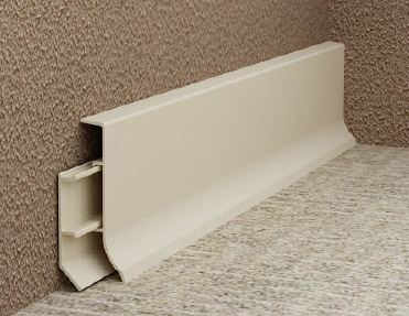 A beige wall with a plastic shelf on it, featuring aluminium skirting.