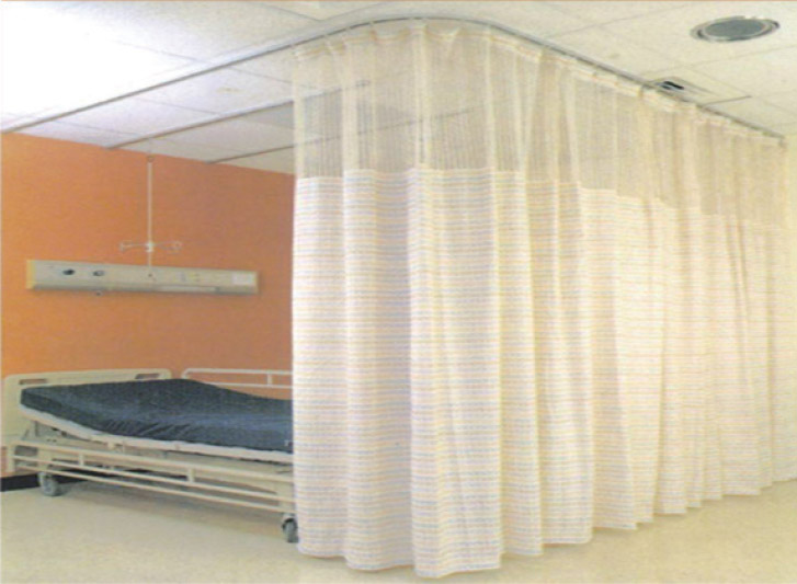 A hospital room with a bed and disposable curtains.