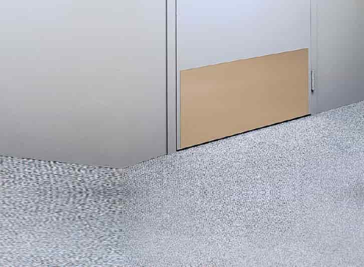 A room with a stainless steel door and a metallic floor.