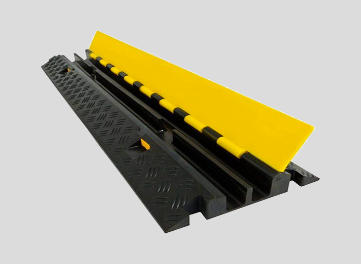A black and yellow plastic barrier with a yellow strip, designed as a cable protector for added safety.