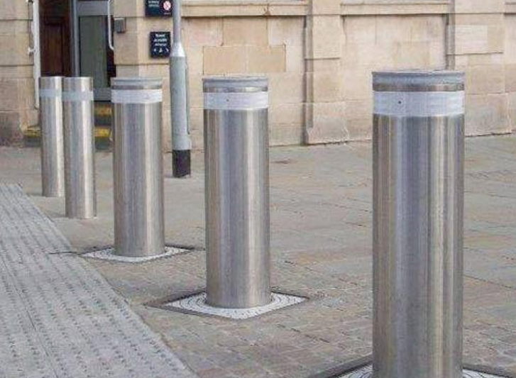 A row of stainless steel bollards in front of a building.
