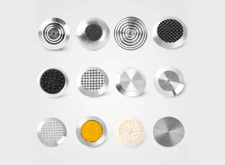 A collection of stainless steel road studs on a white background.