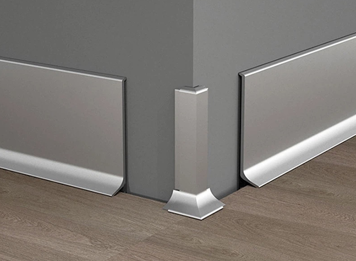A corner of a room with a silver trim made from aluminium skirting.