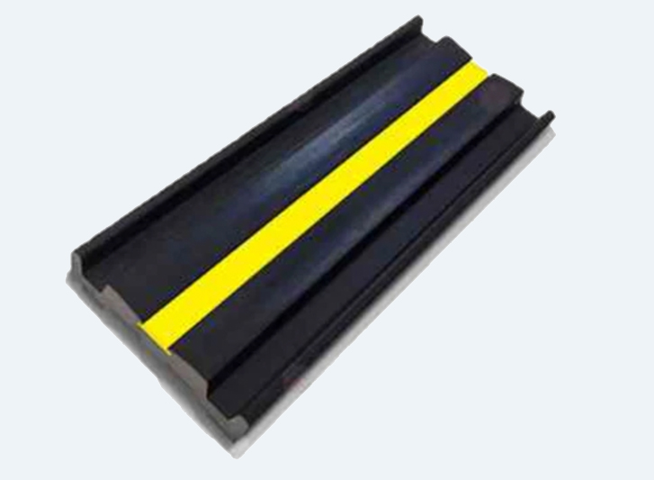 A black and yellow plastic barrier with a yellow stripe and rubber wall guard.